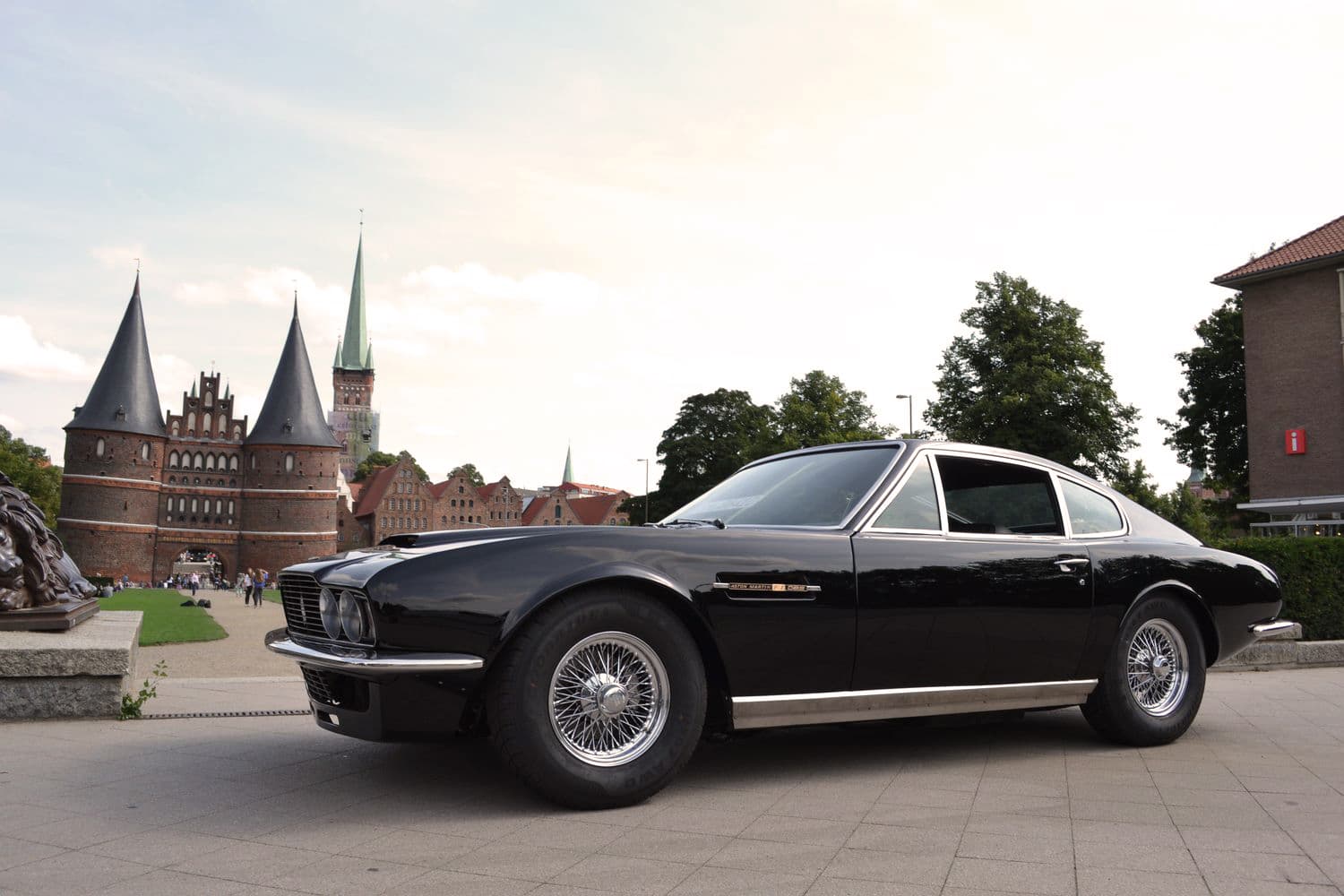 Schwarzer Aston Martin vor dem historischen Holstentor in Lübeck, Deutschland