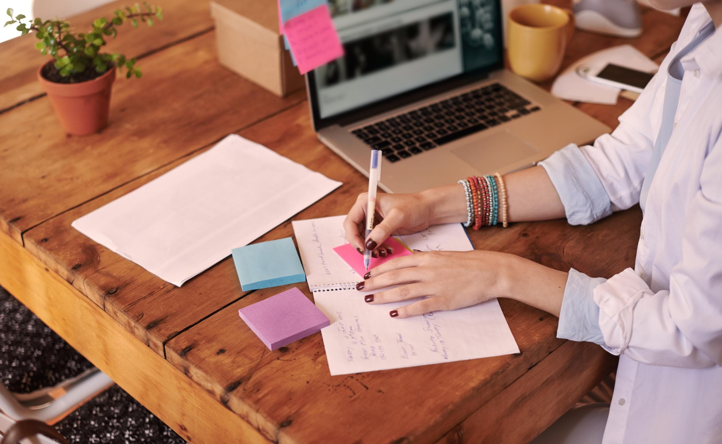 Journalistin bei der Planung und Organisation im Homeoffice: Notizen und Laptop auf einem Schreibtisch